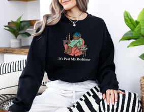 a woman sitting on a couch wearing a black sweatshirt that says it's past