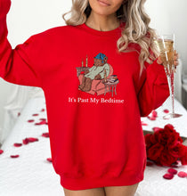 a woman in a red sweatshirt holding a glass of champagne