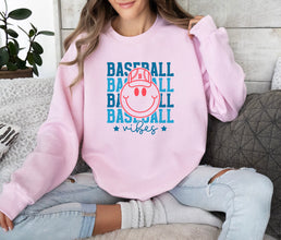 a woman sitting on a couch wearing a pink baseball sweatshirt