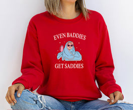 a woman wearing a red sweatshirt that says even baddies get saddles