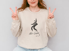 a woman sitting on a stool making the peace sign