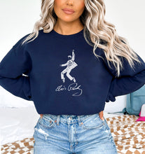 a woman with blonde hair wearing a blue sweatshirt and jeans