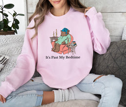 a woman wearing a pink sweatshirt that says it's past my bedtime