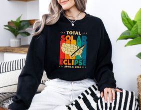 a woman sitting on a couch wearing a black sweatshirt