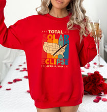 a woman in a red sweatshirt holding a glass of champagne