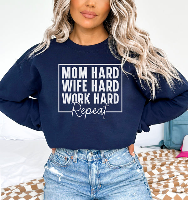 a woman wearing a sweatshirt that says mom hard, wife hard, work hard,