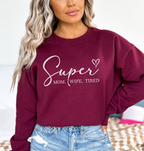 a woman wearing a sweatshirt that says super mom, wife