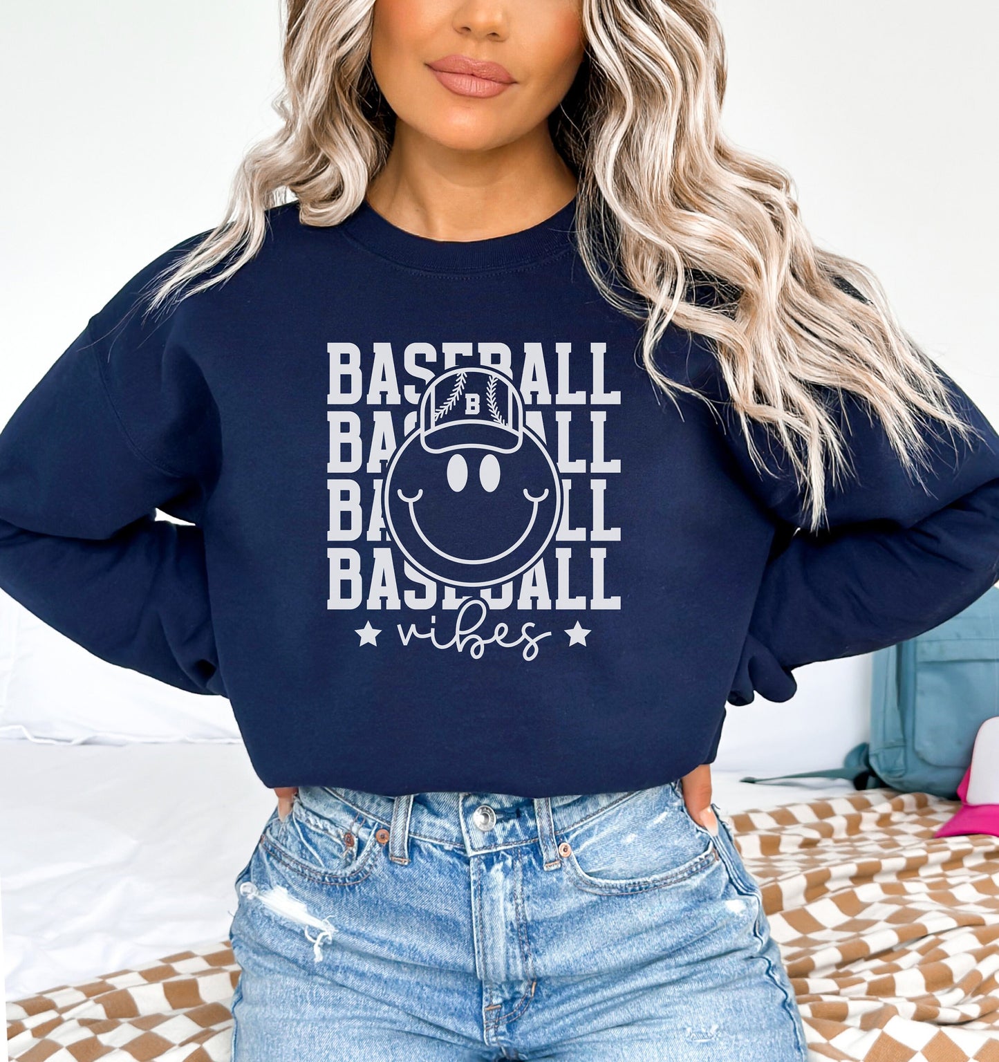 a woman with blonde hair wearing a baseball sweatshirt