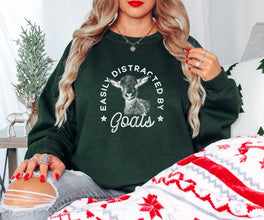 a woman sitting on a couch wearing a green sweatshirt