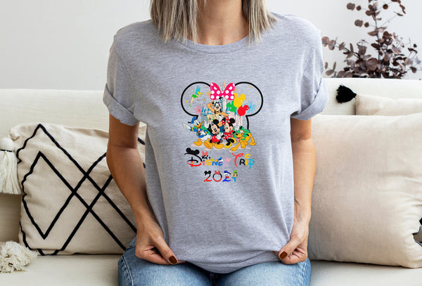 a woman sitting on a couch wearing a mickey mouse shirt