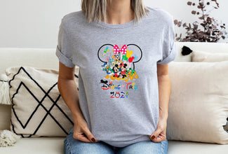 a woman sitting on a couch wearing a mickey mouse shirt