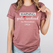 a woman wearing a t - shirt that says warning girls weekend in progress